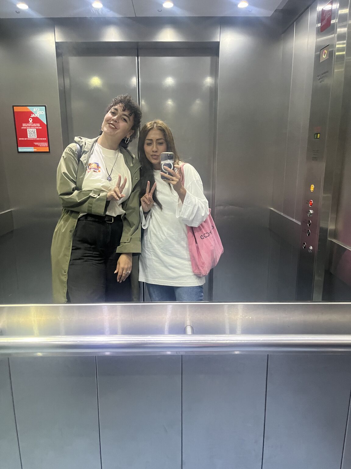 Two women taking a mirror photograph during the week