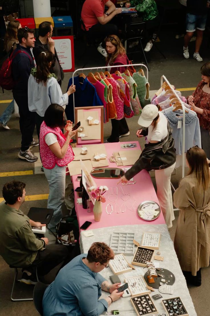 Visitors browsing colourful independent stalls at a busy makers market