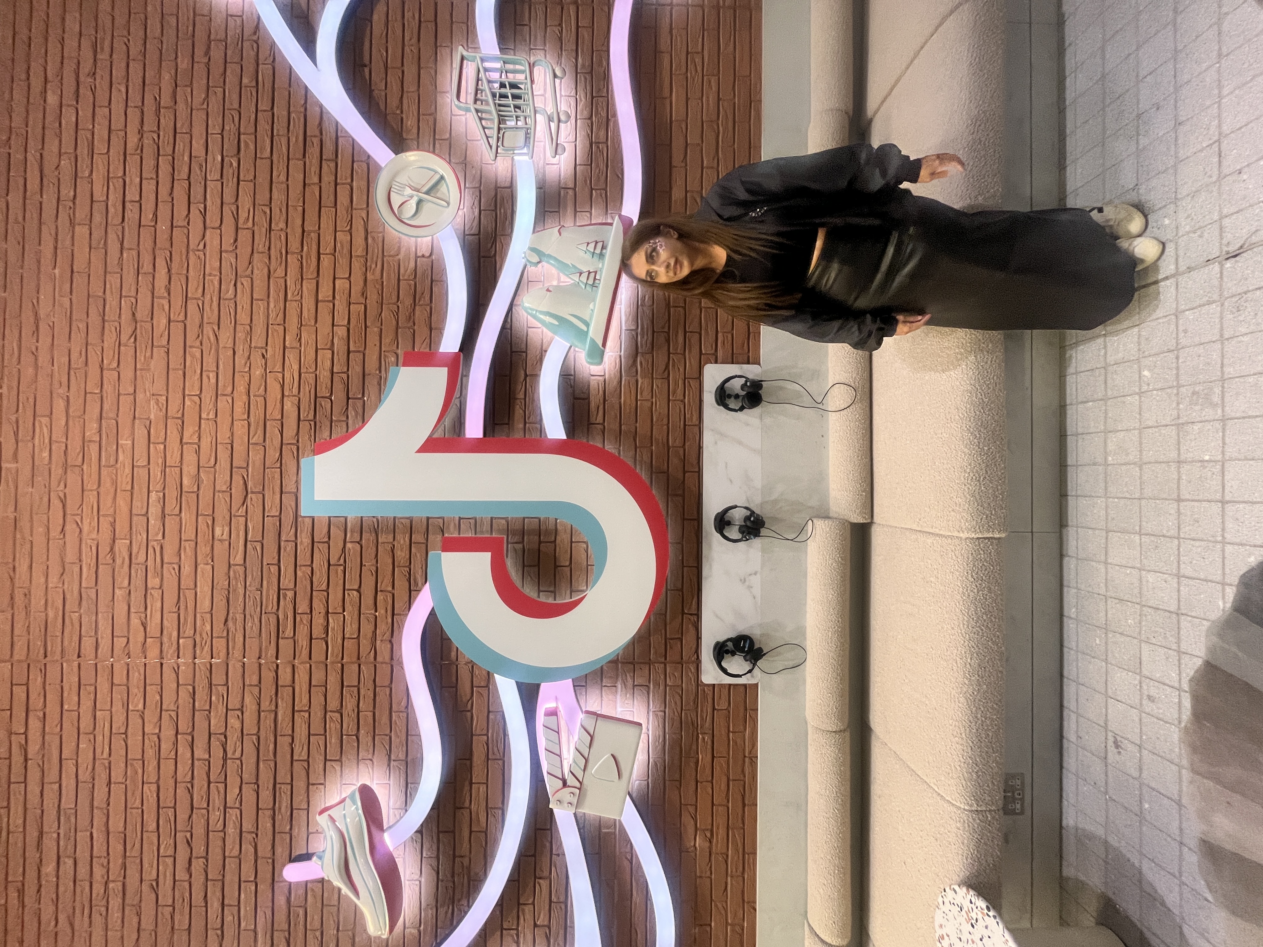 Sima Rahman-Huang standing in front of the TikTok installation at TikTok HQ