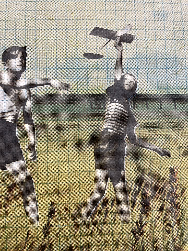 Two young people launching paper planes in a vintage halftone field scene